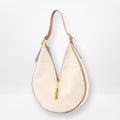 Round sculptural shoulder bag in cream cowhide with gold-brass hardware and signature closing system, handmade by Patricia Bos Designs.
